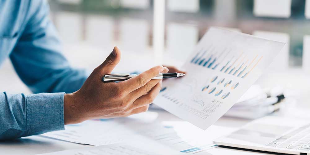 Person with paperwork that shows graphs and charts